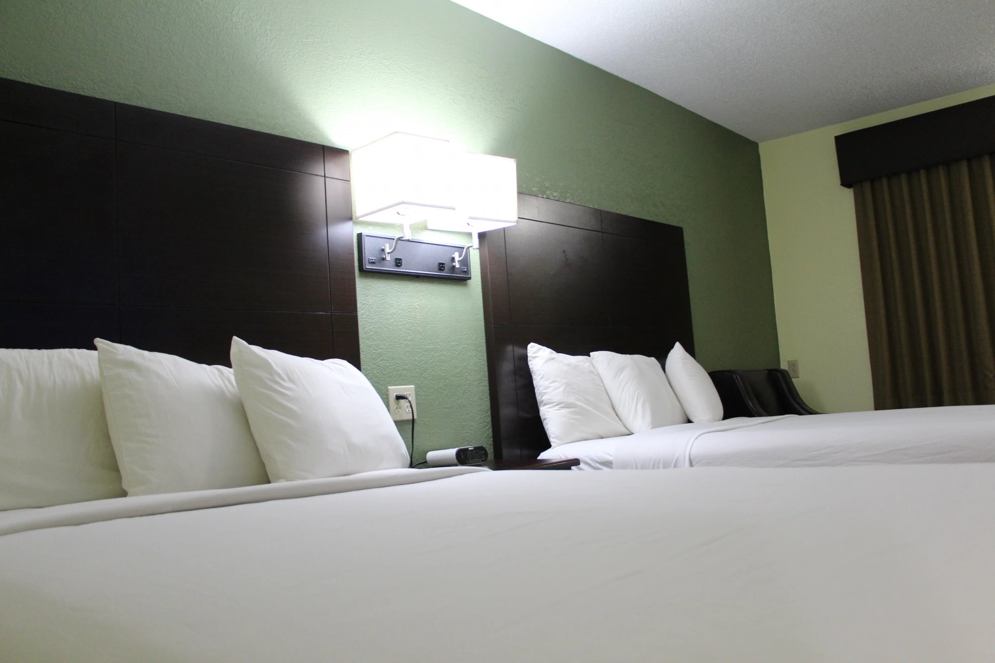 Comfortable queen beds with crisp white linens and warm lighting